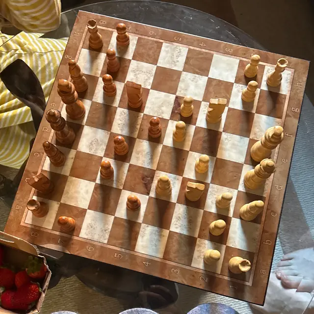 Photo of a wooden board on a glass table in low sunlight, turned sideways to the camera